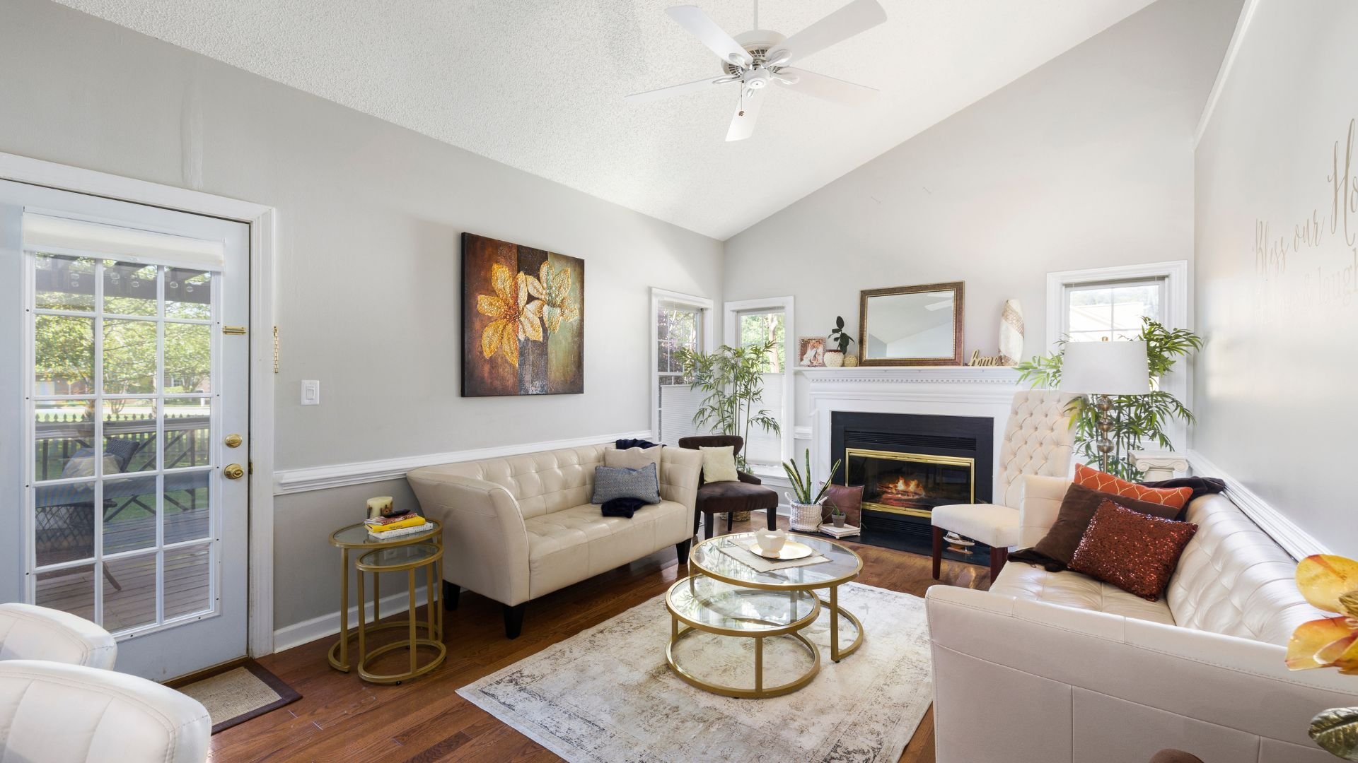 Cozy living room with fireplace, white sofas, and gold accent tables