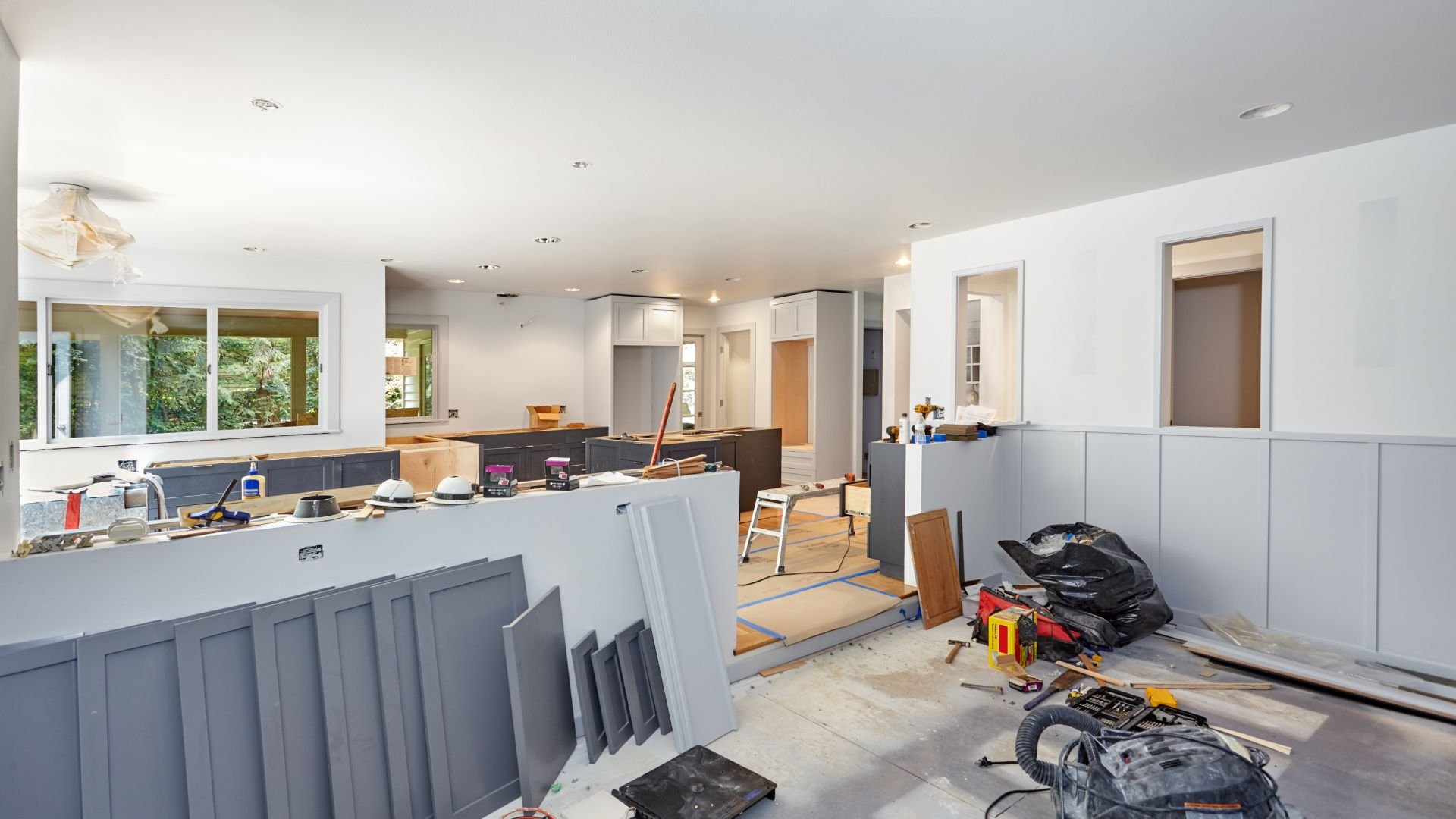 Kitchen renovation in progress with construction materials and tools scattered around