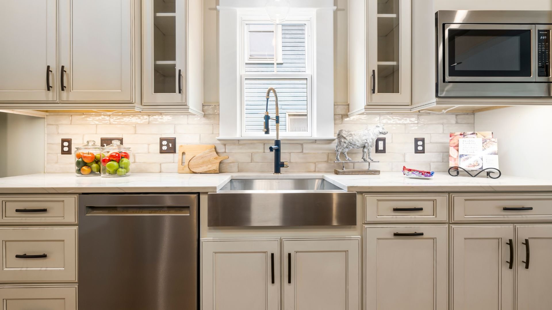 Modern kitchen with stainless steel appliances, white cabinets, and fresh produce